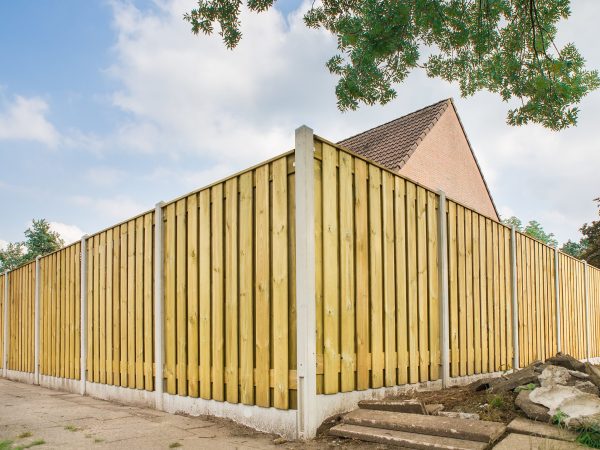 New wooden fence at garden of house New wooden fence as corner around garden of home